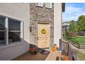 Elegant front door entrance with stone details and deck at 10215 W Wesley Dr, Lakewood, CO 80227