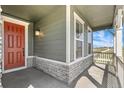 Modern orange front door with stone and gray siding at 11049 Ursula St, Commerce City, CO 80022