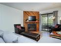 Living room with fireplace, wood-paneled wall and balcony access at 1001 Grandview Dr # 24, Breckenridge, CO 80424