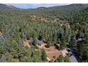Bird's-eye view of a home on a wooded lot in the mountains at 5673 Santa Clara Rd, Indian Hills, CO 80454