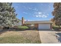 Ranch style home with attached garage and mature landscaping at 542 Melody Dr, Northglenn, CO 80260