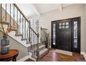 Bright entryway with hardwood floors, staircase, and a dark door at 6269 S Coventry E Ln, Littleton, CO 80123