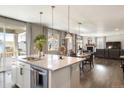 Open concept kitchen with island, stainless steel appliances, and hardwood floors at 728 Larkspur Ct, Brighton, CO 80601