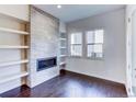 Living room with a built-in fireplace and white shelving at 6435 E Cedar Ave, Denver, CO 80224