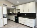Modern kitchen with white cabinets and hexagon tile backsplash at 3414 S Locust St # D, Denver, CO 80222