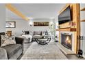 Living room with a gray sectional sofa, fireplace, and wood-paneled accent wall at 3766 S Mission Pkwy # C, Aurora, CO 80013