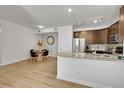 Kitchen and dining area with granite island and wood floors at 10052 W Ute Pl # 206, Littleton, CO 80127