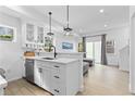 Modern kitchen with white cabinets, breakfast bar, and living room view at 1834 Arapahoe Ave # D, Boulder, CO 80302