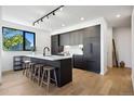 Modern kitchen with dark cabinetry, island, and hardwood floors at 1601 Park Ave # 216, Denver, CO 80218