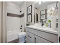 Modern bathroom with a white hexagonal tile shower, white vanity, and black accents at 2644 Sawyer Ln, Erie, CO 80026