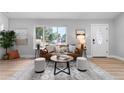 Bright living room with large window, leather sofa, and coffee table at 30 S Yates St, Denver, CO 80219