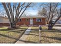 Brick ranch home with attached garage and mature trees at 443 S Robb Way, Lakewood, CO 80226