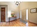 Bright and spacious entryway with hardwood floors and elegant light fixture at 9546 Cherryvale Dr, Highlands Ranch, CO 80126