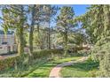 Peaceful walkway winds through a lush green space with mature trees and a charming stone bench at 2227 Canyon Blvd # 253B, Boulder, CO 80302