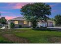 House exterior at dusk showcasing a three-car garage and a landscaped yard at 11685 Salem St, Henderson, CO 80640