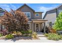 Two-story home with gray siding, landscaping, and a covered porch at 6771 Canosa St, Denver, CO 80221