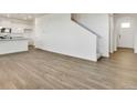 Living room with wood-look flooring, leading to the kitchen and staircase at 162 S Uriah St, Aurora, CO 80018