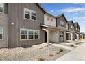 Modern 2-story townhome with gray and beige siding, covered porch, and stone accents at 16728 W 93Rd Pl, Arvada, CO 80007