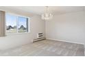 Living room with carpet flooring, a chandelier, large window, and wall-mounted AC unit at 13901 E Marina Dr # 109, Aurora, CO 80014