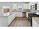 Bright kitchen boasts granite countertops, white cabinetry, and a view of the backyard at 2224 Alyssa St, Fort Lupton, CO 80621