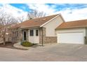 Tan exterior home with attached garage and mature landscaping at 2617 E Egbert St, Brighton, CO 80601