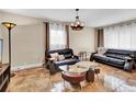 Living room with leather sofas, a coffee table, and large windows at 1219 Tucson St, Aurora, CO 80011