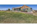 Ranch style home with green siding and red door at 738 S Main St, Byers, CO 80103