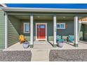 Covered front porch with red door and seating area at 738 S Main St, Byers, CO 80103