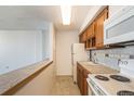 Efficient galley kitchen with wood cabinets and appliances at 1020 15Th St # 37I, Denver, CO 80202
