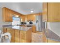 Spacious kitchen featuring light wood cabinets, granite countertops, and stainless steel appliances at 8160 W 81St Pl, Arvada, CO 80005