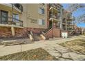 Building entrance with stairs and a bench next to the walkway at 1705 Gaylord St # 107, Denver, CO 80206