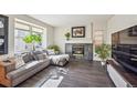 Living room with a fireplace, sectional sofa and large TV at 9828 W 99Th Ave, Broomfield, CO 80021