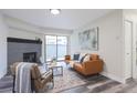 Living room with fireplace, leather couch, and sliding glass doors at 14218 E 1St Dr # A05, Aurora, CO 80011