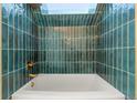 Spa-like bathroom with teal tile and a soaking tub at 17004 E Tennessee Dr # 210, Aurora, CO 80017