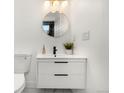 Clean bathroom with a floating vanity and a round mirror at 17004 E Tennessee Dr # 210, Aurora, CO 80017