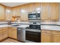 Modern kitchen with light wood cabinets, stainless steel appliances, and granite countertops at 660 S Alton Way # 3B, Denver, CO 80247