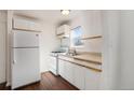 White kitchen with gas range and refrigerator at 1565 Xanthia St, Denver, CO 80220