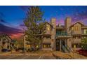 Evening view of a two-story condo building with landscaping at 9510 E Florida Ave # 2052, Denver, CO 80247