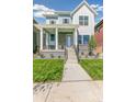 Two-story house with light blue siding, brick accents, and a front porch at 21278 E 63Rd Dr, Aurora, CO 80019