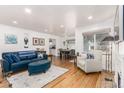 Open living room with hardwood floors, featuring a teal sofa and comfortable seating at 1160 S Monroe St, Denver, CO 80210