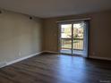 Living room with laminate floors and sliding door to patio at 140 E Highline Cir # 203, Centennial, CO 80122