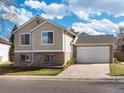 Beige two-story house with attached garage, and a brick base at 9200 Hickory Cir, Highlands Ranch, CO 80126