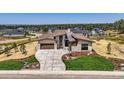 Modern home with expansive driveway and professionally landscaped front yard at 9737 Majestic Oak Dr, Parker, CO 80134