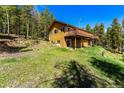 Back of mountain home showcasing large deck and wooded lot at 8 Yuma Trl, Evergreen, CO 80439