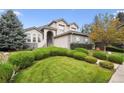 Two-story house with stone accents and manicured lawn at 7379 S Ukraine St, Aurora, CO 80016