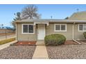 Tan siding townhouse exterior with a white door and small landscaping at 5711 W 92Nd Ave # 15, Westminster, CO 80031