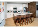 Modern kitchen with island, stainless steel appliances, and white cabinetry at 5968 N Lisbon St, Aurora, CO 80019