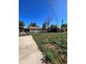 Backyard with a large grassy area and a paved driveway at 2080 Emporia St, Aurora, CO 80010