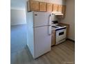 White appliances and light wood cabinets in this kitchen at 8031 Wolff St # H, Westminster, CO 80031