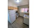 Simple kitchen with light cabinets, white appliances, and laminate flooring at 8031 Wolff St # H, Westminster, CO 80031
